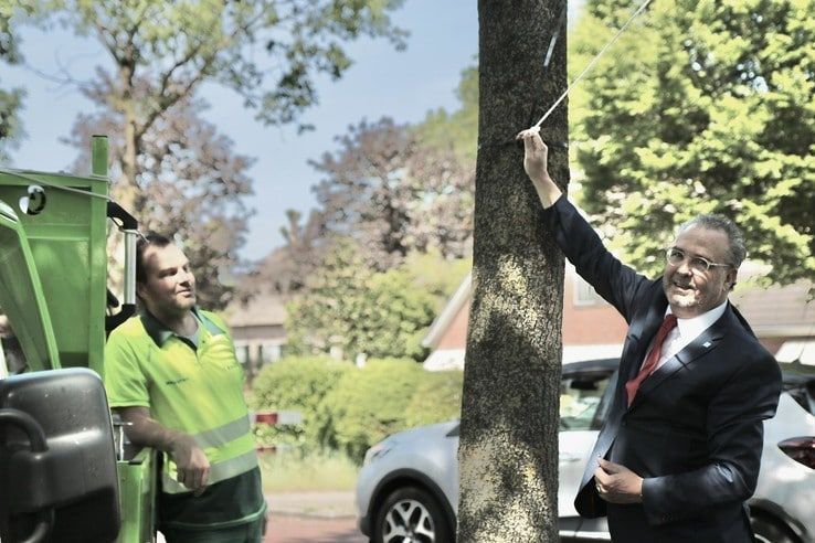 Wethouder William Dogger hangt een spandoek op aan de Nieuwe Deventerweg - Foto: Ingezonden foto