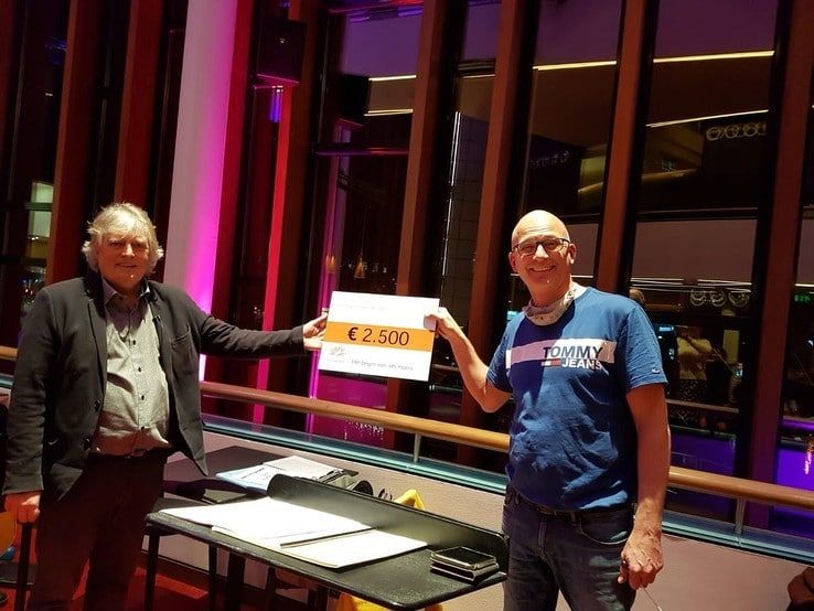 Dinand Webbink, bestuurslid van het Cultuurfonds Overijssel, overhandigt de cheque aan Albert Dam, dirigent van De Vuurvogel. - Foto: Overijssels Cultuurfonds