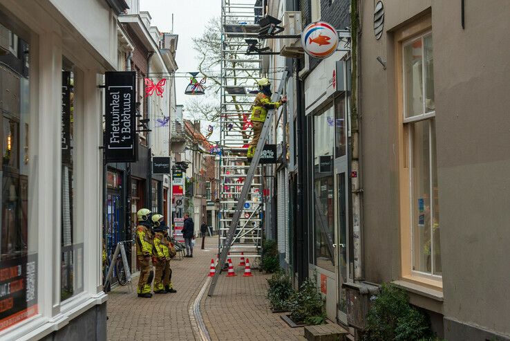 Storm Evert rukt gevelplaat van winkel in Roggenstraat - Foto: Peter Denekamp