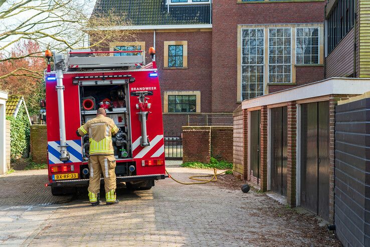 Buren voorkomen dat schuur in vlammen opgaat in de Veerallee - Foto: Peter Denekamp
