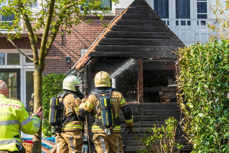Buren voorkomen dat schuur in vlammen opgaat in de Veerallee - Foto: Peter Denekamp