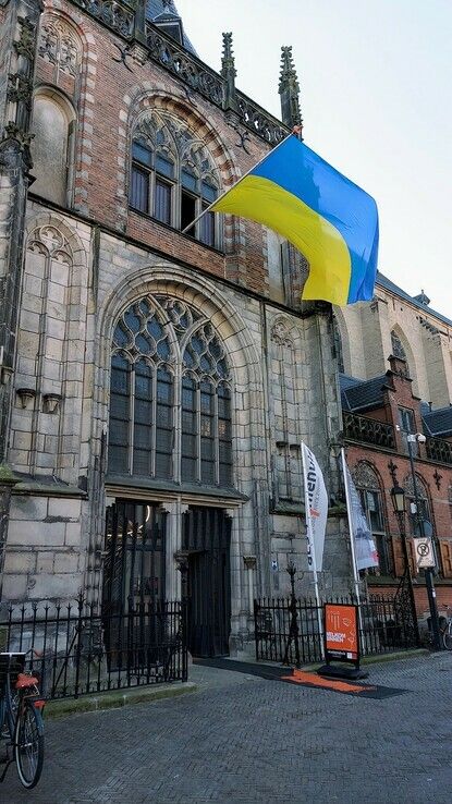 Oekraïense vlag boven noorderportaal Grote Kerk