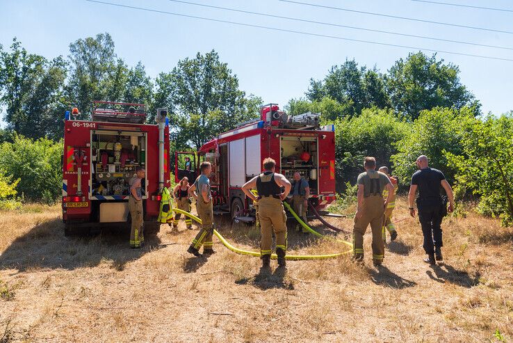 Brandweerlieden werken zich in het zweet om bosbrand in Herfte te bestrijden - Foto: Peter Denekamp